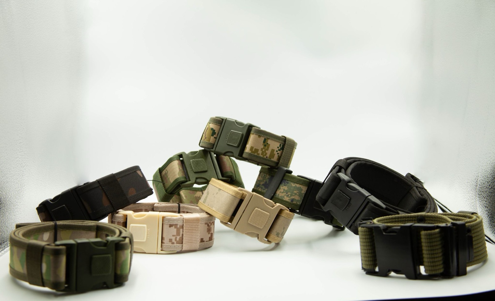 Several webbing duty belts with quick-release buckles in black and camouflage