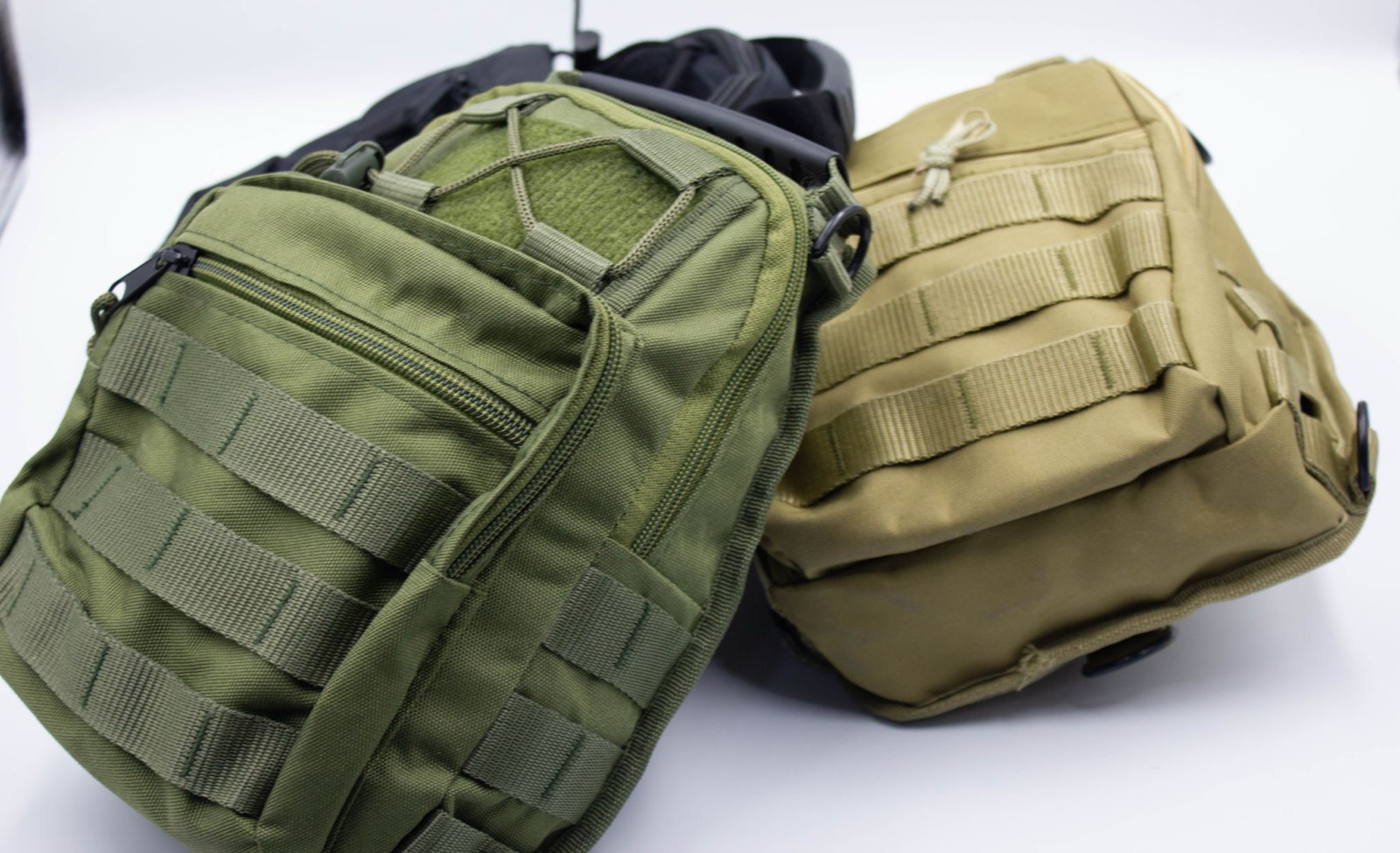 Two compact tactical sling bags in olive green and coyote tan