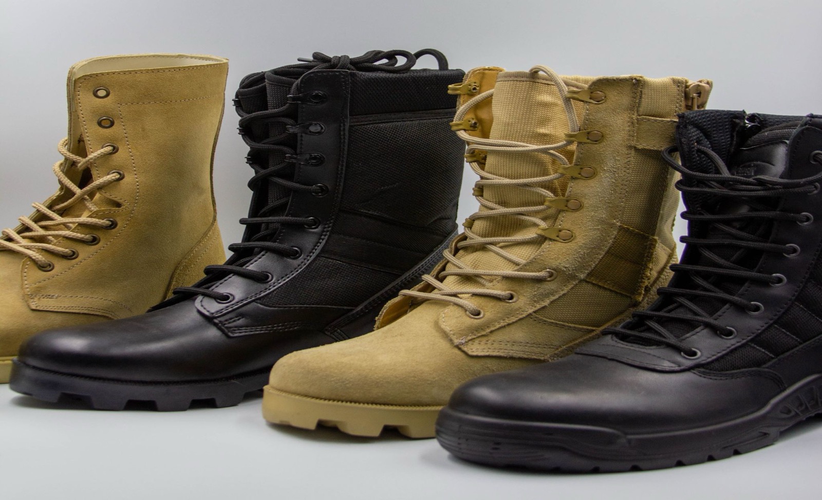 Four tactical field boots in tan suede and black leather lined up in a row