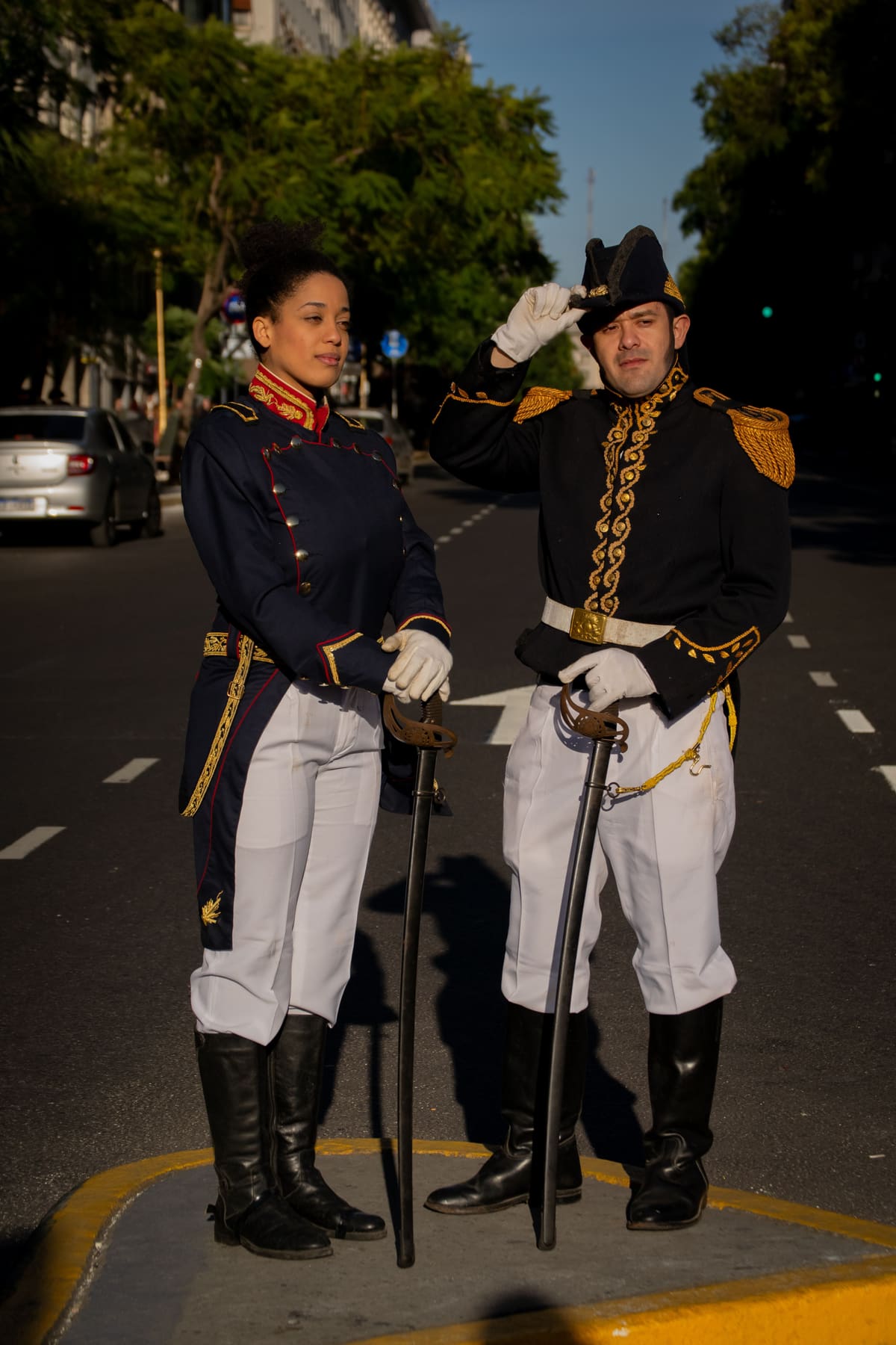 Two ceremonial honor guards in gold-braided dress uniforms holding ceremonial swords