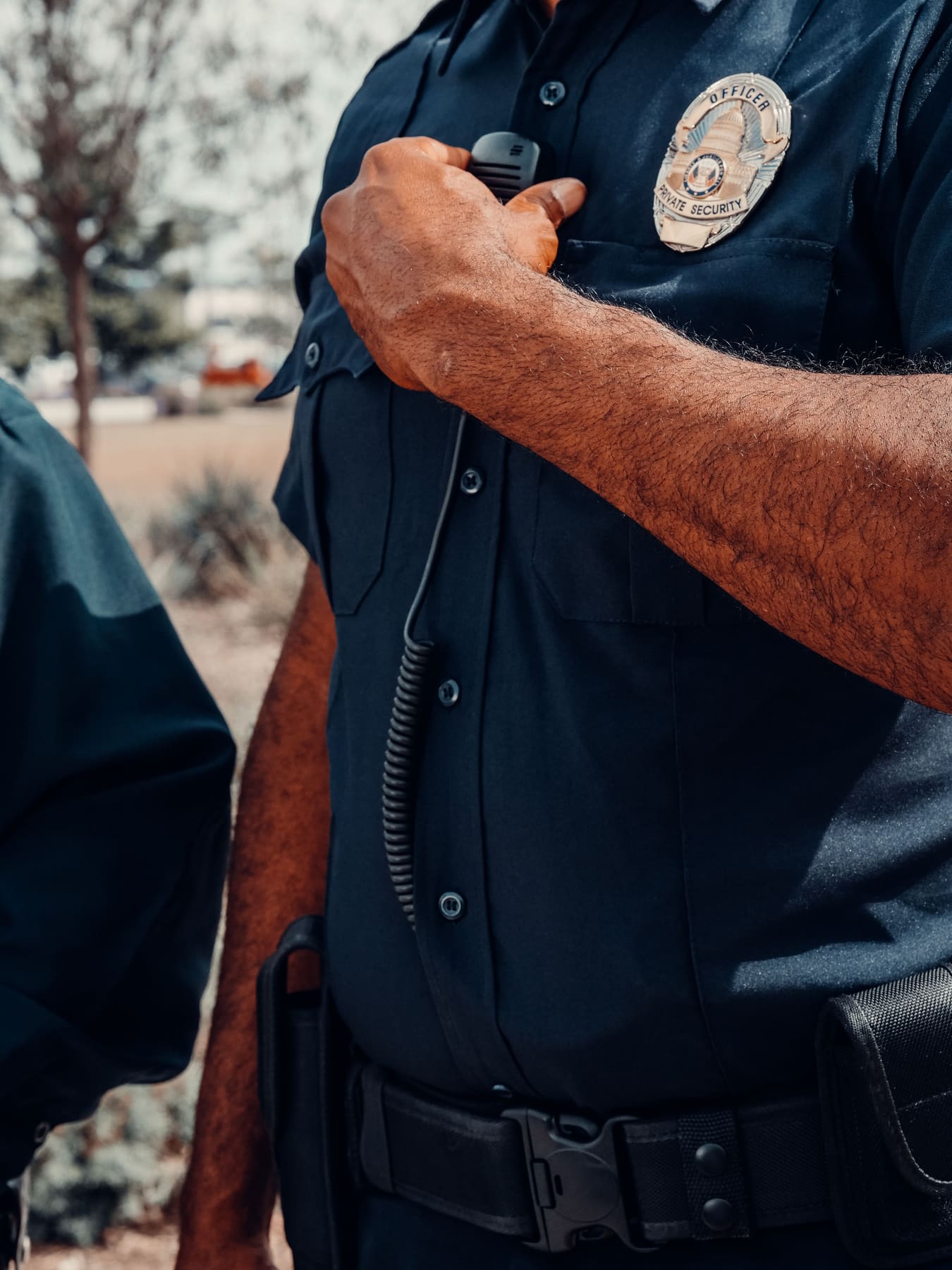 Detail of a private security officer's uniform shirt and badge